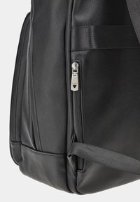 Zaino sintetico nero con esterno testurizzato, dotato di una cerniera silver con coulisse brandizzata, tracolla regolabile e forma strutturata.