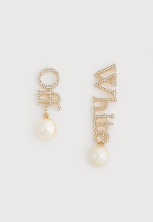 Gold-tone earrings with sparkling letters spelling "Off" and "White," each featuring a large dangling pearl against a white background.