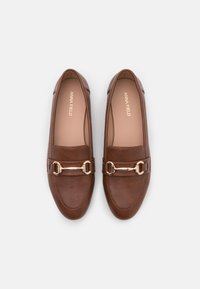 Mocassins en cuir marron avec un accent en chaîne doré sur le devant. Design à bout rond avec une texture lisse.