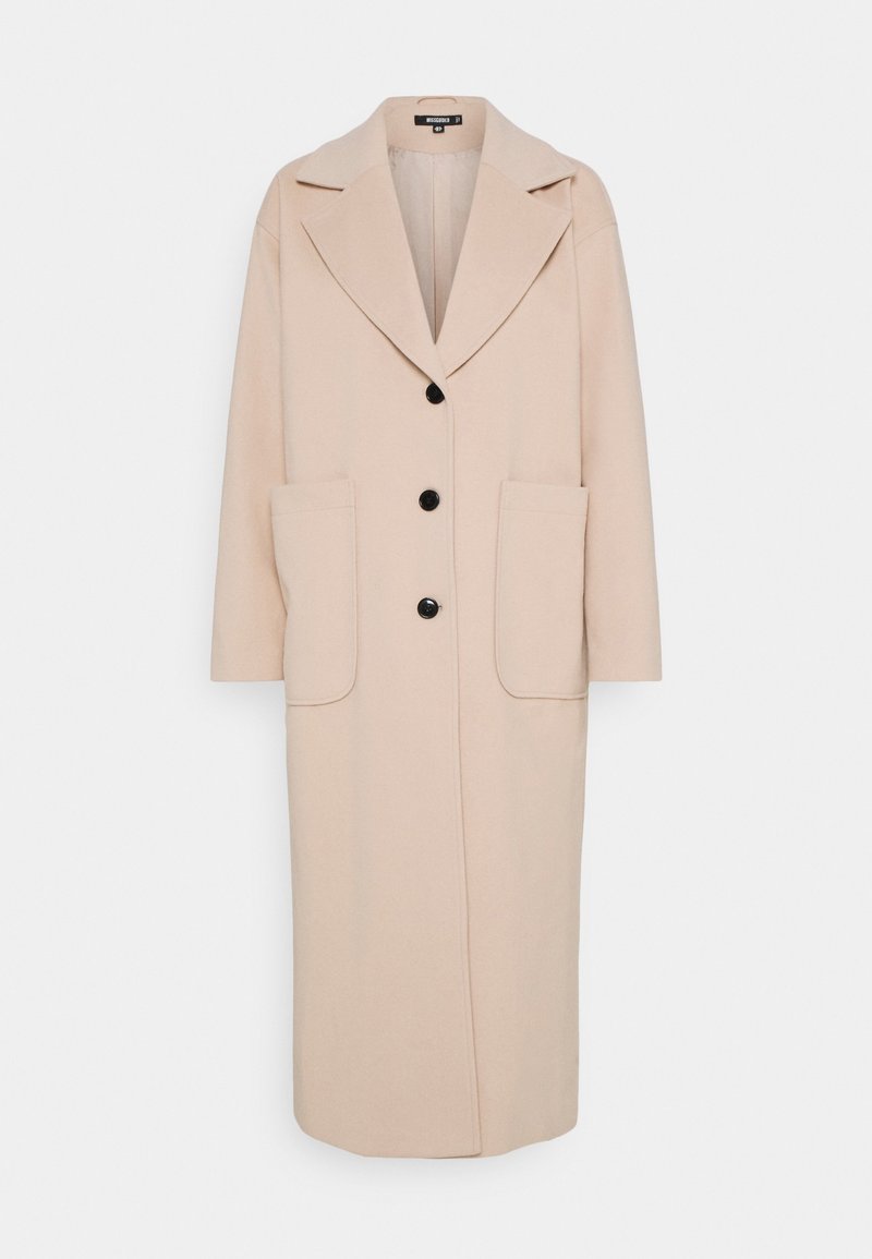 Long manteau beige avec larges revers, trois boutons noirs et grandes poches plaquées devant, présenté sur fond blanc.