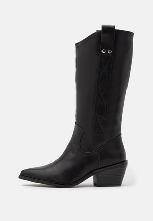 Botte western noire en cuir mi-mollet avec bout pointu, talon bloc et coutures décoratives sur la tige avec languettes de tirage.