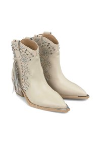 Bottines en cuir beige avec des pointes pointues, ornées de clous en argent, d'accents bleus et de détails en franges à l'arrière. Embout métallique hexagonal.