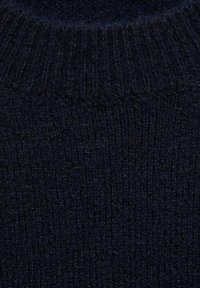 Temna mornarsko modra majica s rebrastim ovratnikom. Narejena iz mehke, teksturirane tkanine z gosto pletenim vzorcem, ki ima dosleden odtenek skozi celotno. 