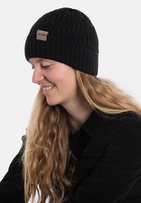 Czarna dziana czapka beanie z teksturowanymi wzorami, z skórzaną metką. Posiada dopasowany krój i prążkowany brzeg dolny dla dodatkowego ciepła.