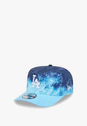 Casquette de baseball avec logo LA, motif vague océanique sur la calotte, et visière incurvée bleu clair, avec un drapeau New Era sur le côté.