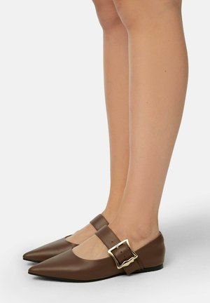 Ballerine in pelle marrone con punta affusolata, dotate di una larga cintura e di una fibbia dorata. Il design è minimalista con una suola piatta.