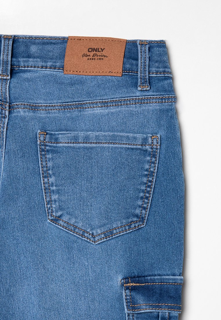 Blauwe denim jeans met een bruine leren label met de tekst "ONLY." Kenmerken zijn onder andere een achterzak en stikseldetails.