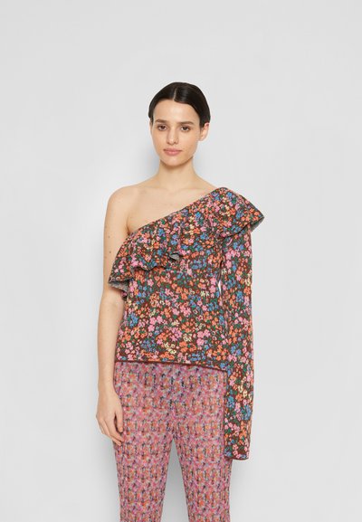 Top floral assimétrico com detalhes em babados, cores vibrantes sobre um fundo escuro, combinado com calças estampadas texturizadas em rosa.