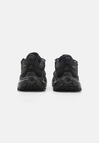 Černé voděodolné turistické boty s texturovanou tkaninou, polstrovanými límci a robustními gumovými podrážkami s výrazným vzorem pro zpevnění. 