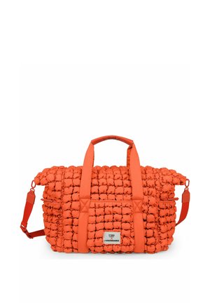 Bright orange quilted duffel bag with padded handles, adjustable shoulder strap, and front logo patch, set against a white background.
