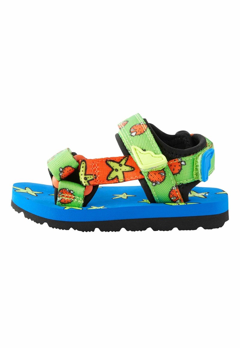 Die Kindersandalen haben eine blaue Schaumsohle, eine schwarze strukturierte Unterseite und bunte Riemen mit Mustern von Seesternen und Tieren in Grün und Orange.