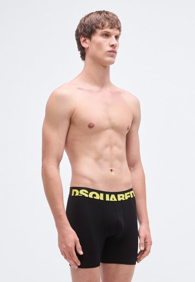 Bóxers negros con un logo amarillo "DSQUARED" en la cintura, con un diseño ajustado y tejido suave y elástico.