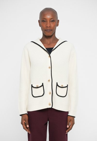 Cardigan a maglia waffle in crema con rifiniture nere, dotato di cappuccio, bottoni oro e due tasche frontali con bordi curvi.