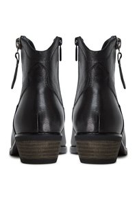 Botines de cuero negro con acabado texturizado, cremalleras laterales y tacones bajos apilados con rayas verticales.