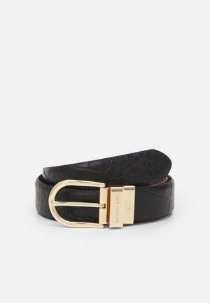 Ceinture en cuir noir texturé enroulée avec une boucle en métal doré gravée de "MICHAEL KORS" et du logo MK, présentée sur un fond neutre.