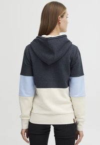 Sweat-shirt à capuche en bleu marine, bleu clair et crème. Doté d'un design coloré avec une texture douce et des poignets et un ourlet côtelés.