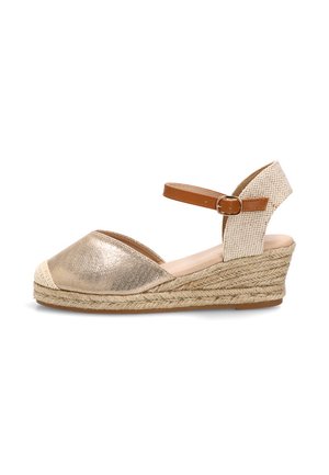 Sandalia cuña dorada con puntera cerrada, suela de cuerda trenzada, tira de talón texturizada beige y correa marrón ajustable con hebilla en el tobillo.