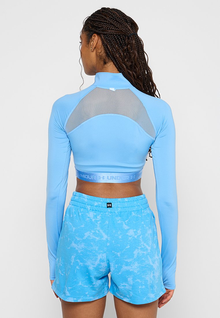 Top corto blu a maniche lunghe con dettagli in rete e scollo rotondo, abbinato a pantaloni corti blu con un motivo marmorizzato e cintura elastica.