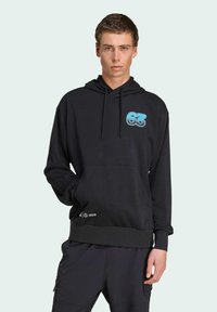 Sweat à capuche noir avec un grand graphique "63" bleu clair sur la poitrine, capuche à cordon de serrage, poche avant, et bords côtelés aux poignets et à l'ourlet.