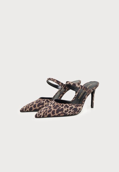 Paire de mules à talons hauts pointues pour femmes avec imprimé léopard et deux fines brides sur le dessus, sur fond gris clair.