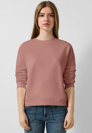 Stofrozen rozen sweatshirt met een ronde hals, ribbelmanchetten en onderrand. Bevat een klein logo op de borst en heeft een losse pasvorm. Gecombineerd met blauwe jeans.