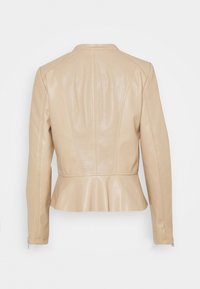Chaqueta de cuero beige con paneles perforados en la espalda y las mangas, cintura entallada y puños con cremallera, vista desde atrás.