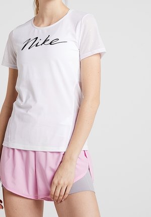 T-shirt de sport blanc avec logo "Nike" noir, manches courtes transparentes, accompagné de shorts de course roses avec accents gris et fentes latérales.