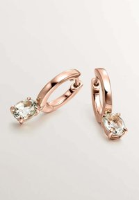 Los pendientes de aro color oro rosa presentan una piedra preciosa ovalada y clara, enclavada en un engaste de garras, con una textura suave y un acabado brillante.