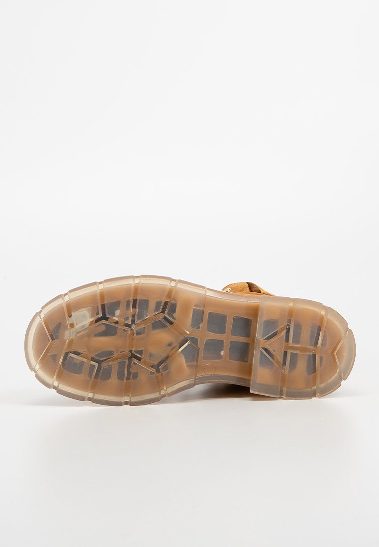 Transparente Gummisohle von Sneakern mit einem geometrischen Profil, in einer hellbraunen Farbe und mit strukturierter Oberfläche für besseren Halt.