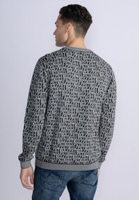 Hanorac pentru bărbați cu guler rotund, având un design cu model în albastru închis și bej, cu manșete și tiv dantelate. Fabricat dintr-un material moale.