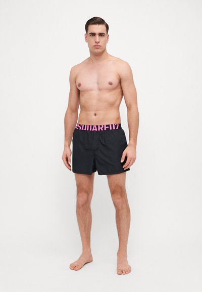 Schwarze Badehorts mit einem pinken elastischen Taillenbund, versehen mit einem Logo. Die Shorts bestehen aus leichtem Material und haben einen lockeren Schnitt.