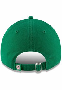 Grüne Baumwoll-Baseballmütze mit gebogenem Schild, verstellbarem silbernen Zubehör und einem weißen Logoetikett auf der Rückseite. Strukturiertes Stofffinish.