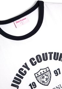 Balta marškinėliai su juodu apykaklės kraštu, su ryškiu juodu užrašu "JUICY COUTURE" ir futbolo šalmą primenančiu logotipu, su rožiniu etikete vidinėje apykaklės pusėje.