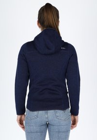 Felpa blu navy con tessuto texturizzato, cappuccio con cordino e design aderente, caratterizzata da cuciture a contrasto e un piccolo logo sulla spalla.