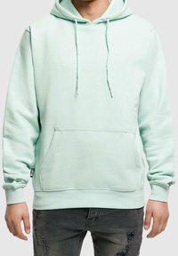 Felpa con cappuccio verde menta, dotata di tasca frontale, lacci e polsini a coste. Realizzata in tessuto morbido, presenta una vestibilità rilassata e dettagli minimali.