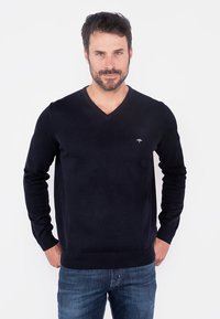 Pulover slim-fit de culoare bleumarin, cu decolteu în V, fabricat dintr-un material tricotat moale, având mâneci lungi și un logo mic pe piept în partea stângă.