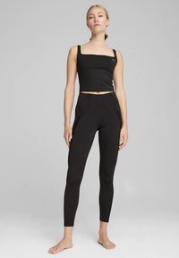 Top nero cropped con spalline e leggings a vita alta in tessuto elasticizzato. Presentano uno scollo quadrato e dettagli cuciti sui pantaloni.