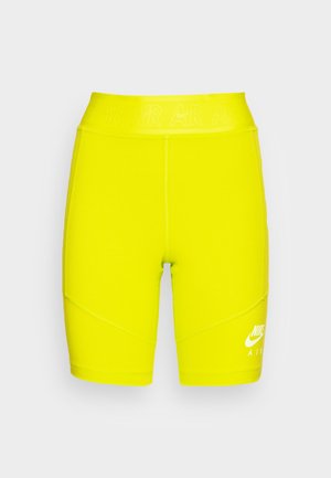 Gelbe hoch taillierte Sportshorts aus elastischem Material, mit weißem Nike-Logo und Text am Bund, und detaillierten Nahtmustern.
