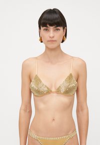 Gouden paillettentop met driehoekige cups, verstelbare bandjes en bijpassende onderkant met paillettenaccenten langs de randen.