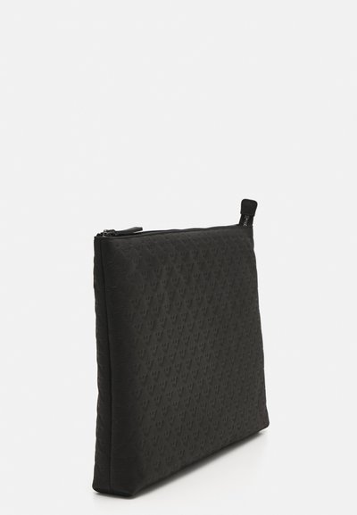 Black zippered pouch with textured pattern of raised triangles, rectangular shape, smooth finish, and a small loop at the zipper pull.