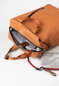 Zaino in pelle color tan con apertura superiore, dotato di rivestimento a quadretti grigi, un tirante rosso e una tasca più piccola abbinata con cerniera rossa.