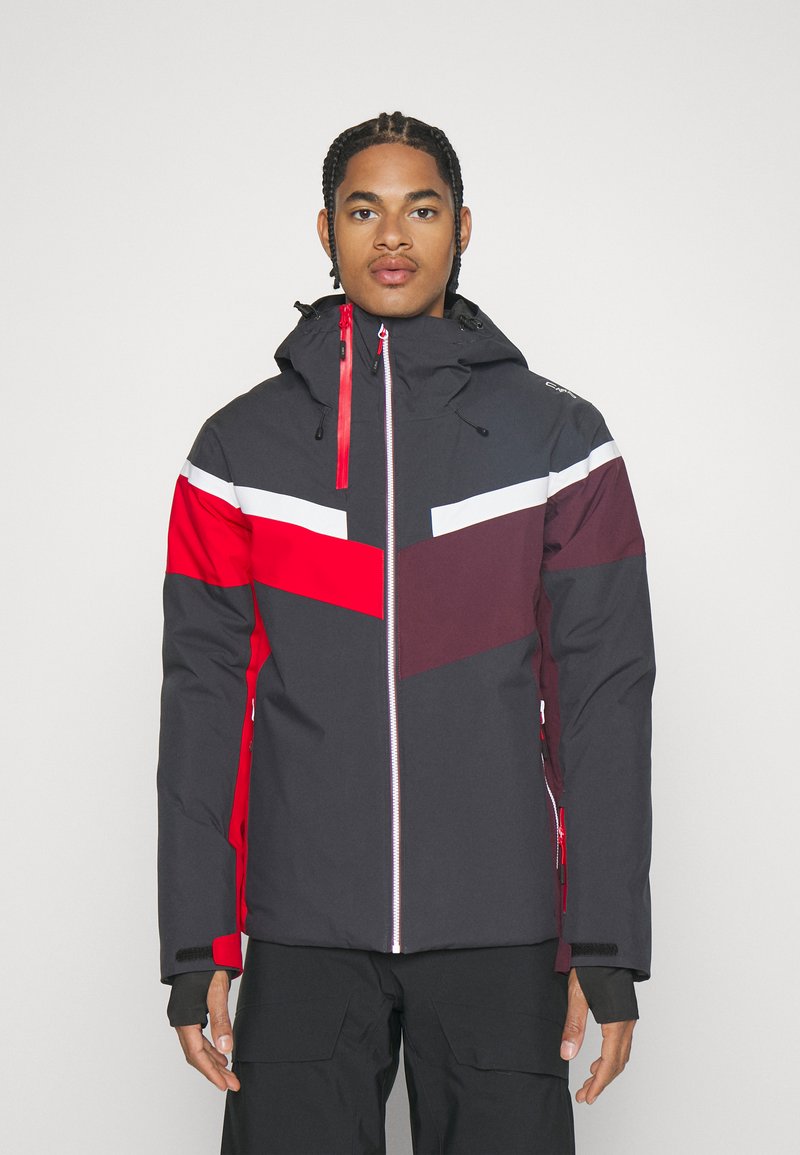 Giacca impermeabile color block con base nera e accenti rossi, bianchi e bordeaux. Design con cappuccio, zip frontale e caratteristiche regolabili.