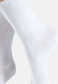 White cotton socks with a ribbed cuff, smooth texture, and a fitted shape. The design features a classic ankle length for comfort.