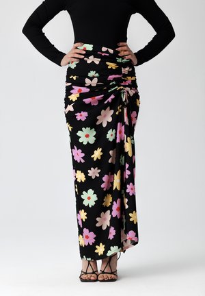 Jupe maxi noire à motifs floraux avec des fleurs multicolores en rose, jaune et vert. Design froncé avec un détail à nouer ajustable sur le côté.