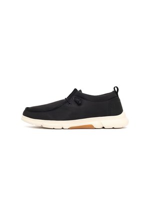 Czarny sneaker typu slip-on z białą podeszwą, elastycznymi sznurowadłami i pętlą ułatwiającą zakładanie na pięcie, pokazany z zewnętrznej strony na białym tle.