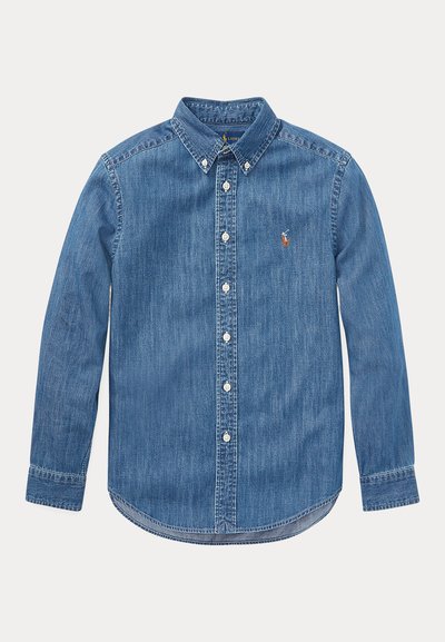 Chemise en denim bleu à manches longues, boutonnée, avec un col pointu et un petit logo brodé sur la poitrine gauche.
