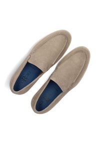 Beige suède instappers met een ronde neus, een contrasterende blauwe binnenzool en gedetailleerde stiksels langs de bovenrand.