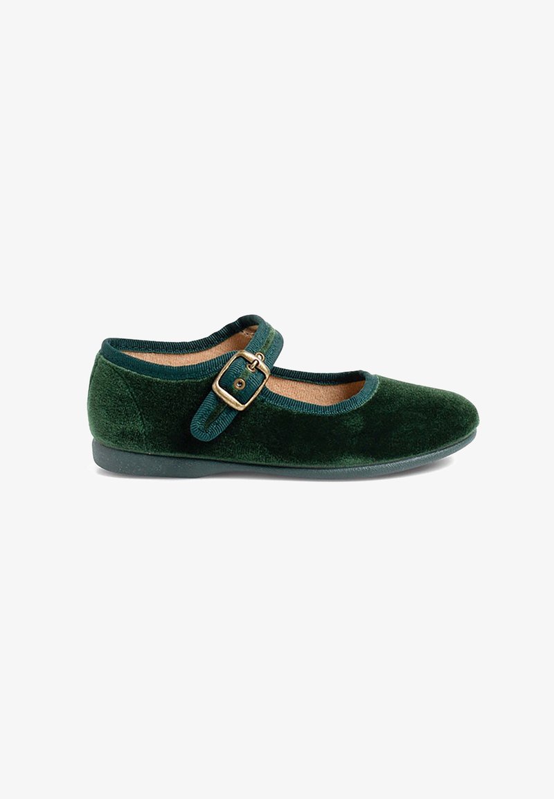 Une chaussure Mary Jane en velours vert foncé avec une bride à boucle dorée et une semelle noire plate sur fond blanc.