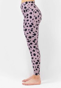Leggings made of stretchy, textured fabric in light lavender with black irregular spots; high waist design and ankle-length.