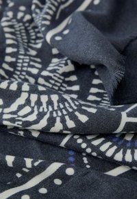 Donkerblauwe sjaal met witte en lichtblauwe abstracte patronen, met een zachte textuur en franjes voor extra detail.